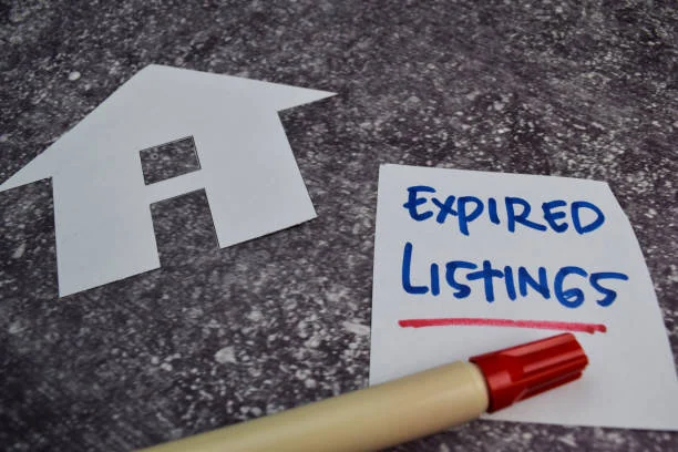 Paper house cutout beside a handwritten note that reads Expired Listings